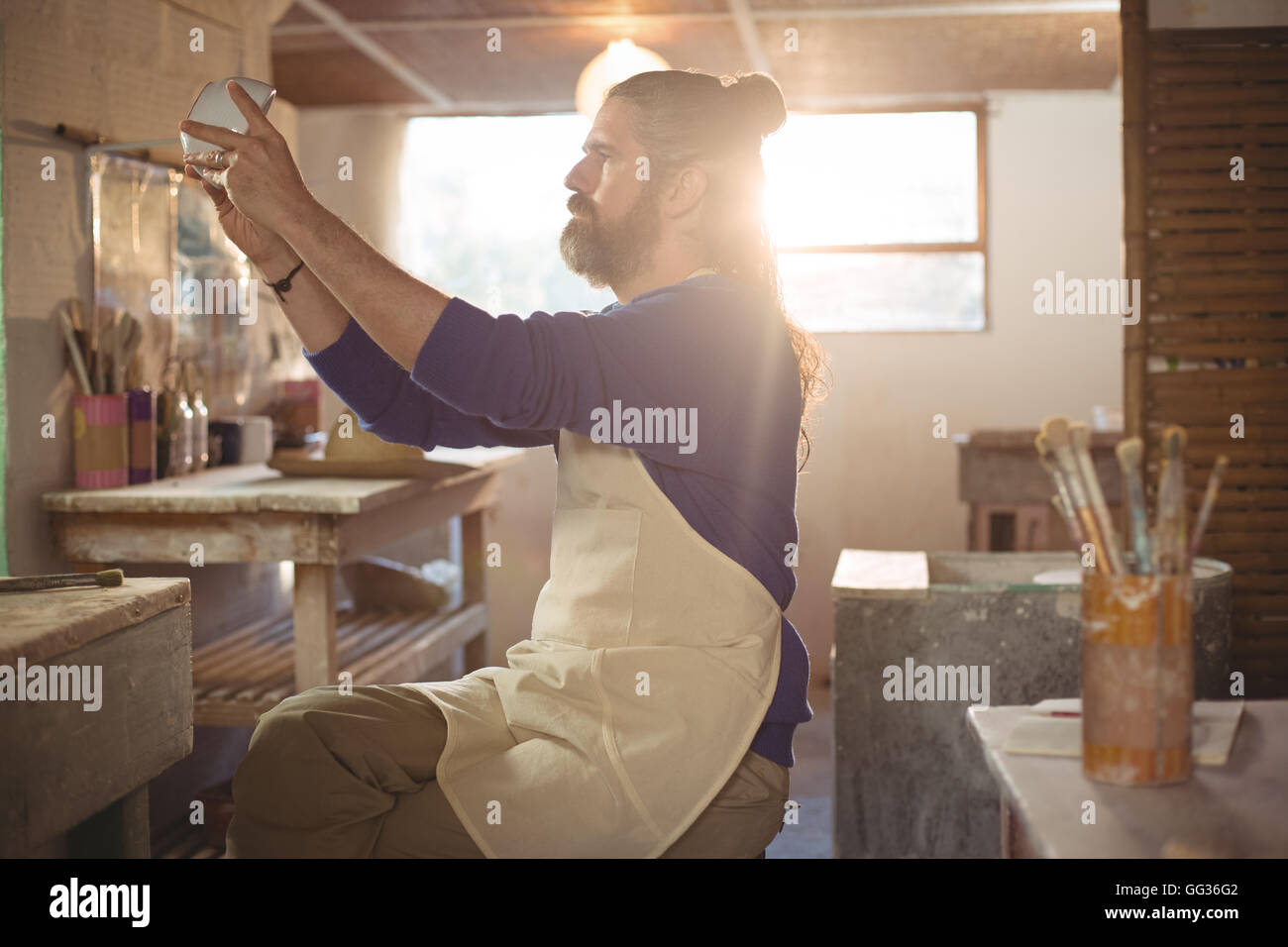 Male potter checking bowl Stock Photo - Alamy