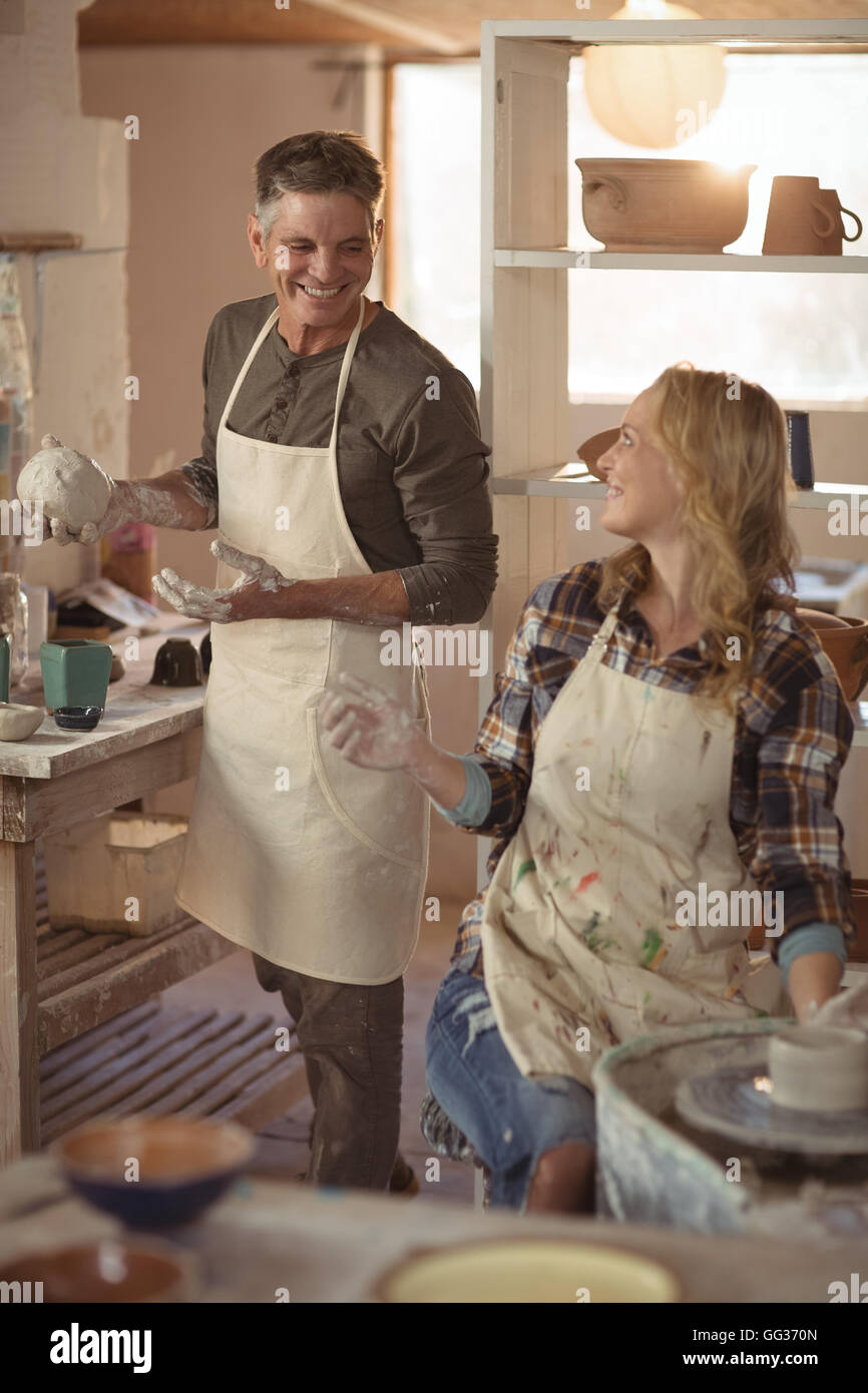 Potters interacting while making pot in pottery workshop Stock Photo ...