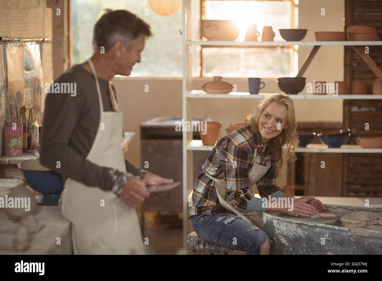 Potters interacting in pottery workshop Stock Photo - Alamy