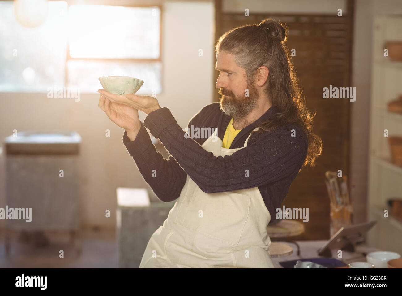 Male potter checking bowl Stock Photo - Alamy