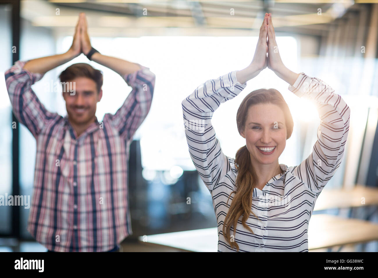 Smiling business people performing yoga in office Stock Photo - Alamy