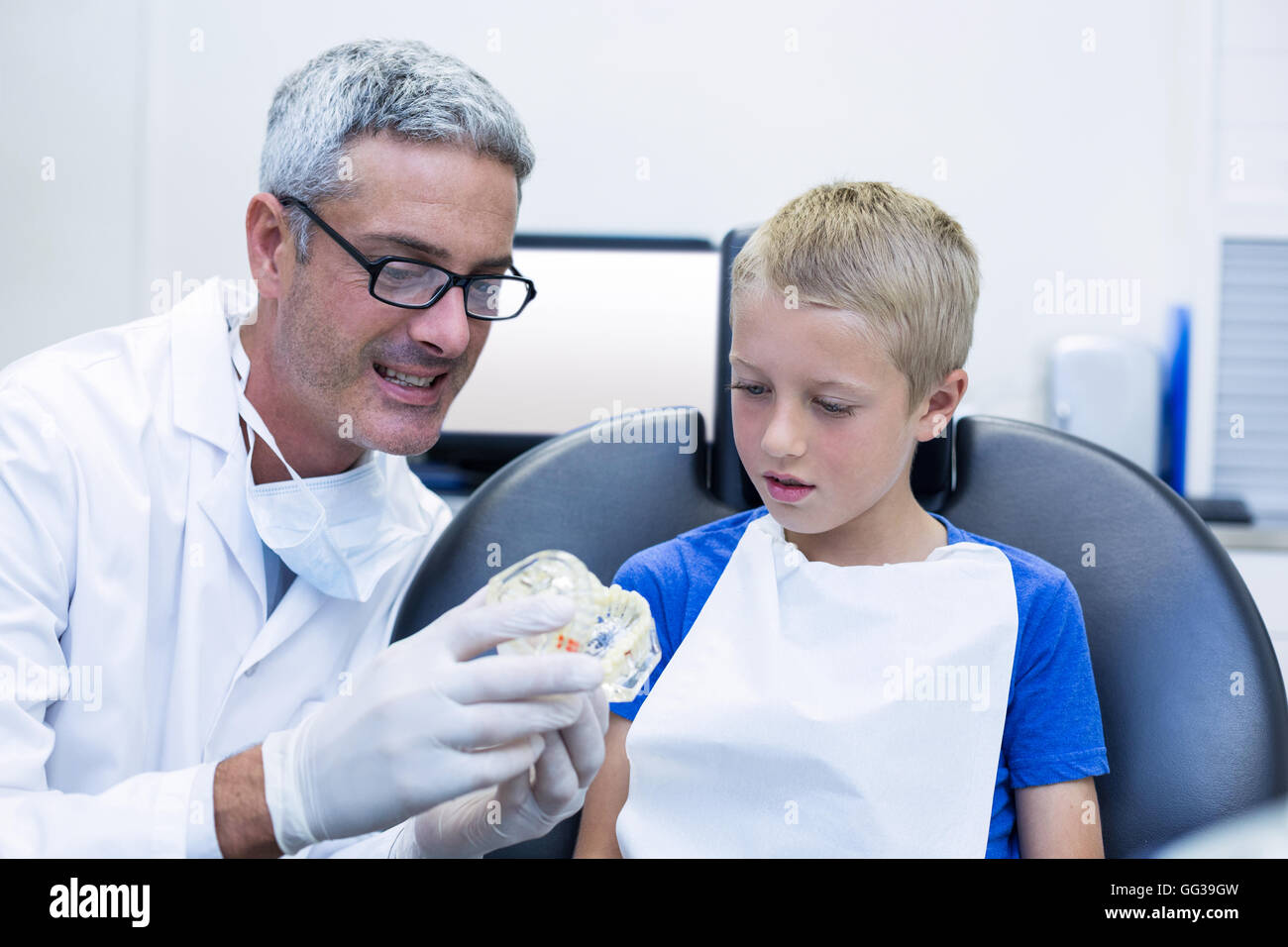 Dentist showing model teeth to patient Stock Photo - Alamy