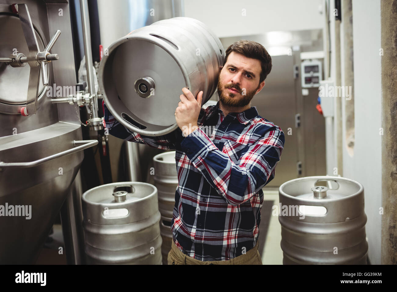 Manufacturer carrying keg in brewery Stock Photo Alamy