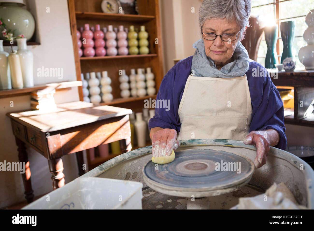 Female potter cleaning pottery wheel Stock Photo Alamy