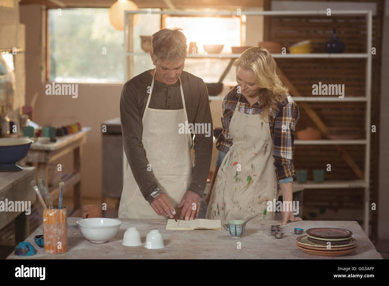 Potters writing in book Stock Photo