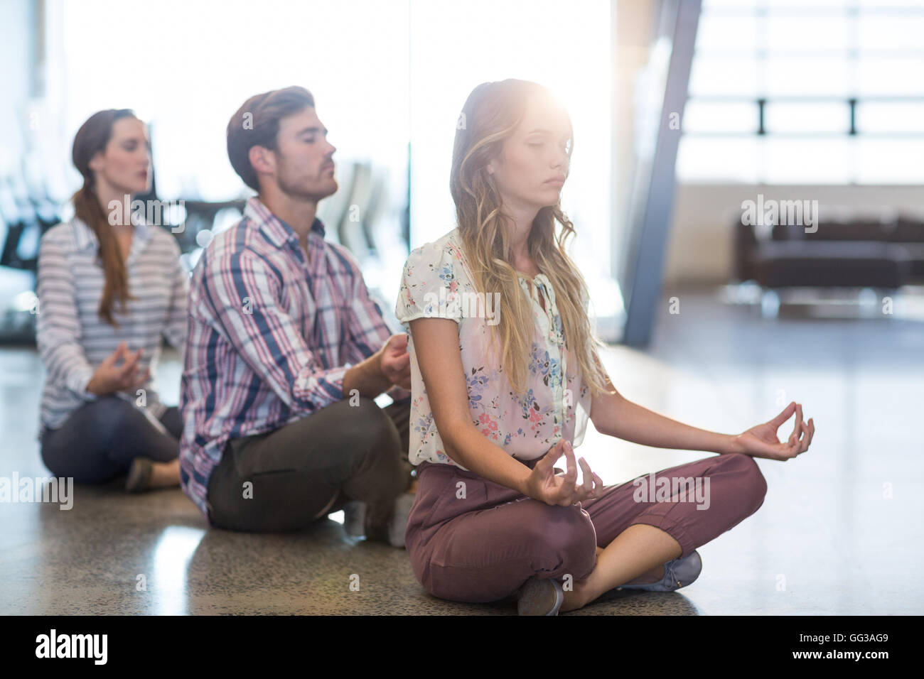 Business people performing yoga on floor Stock Photo - Alamy