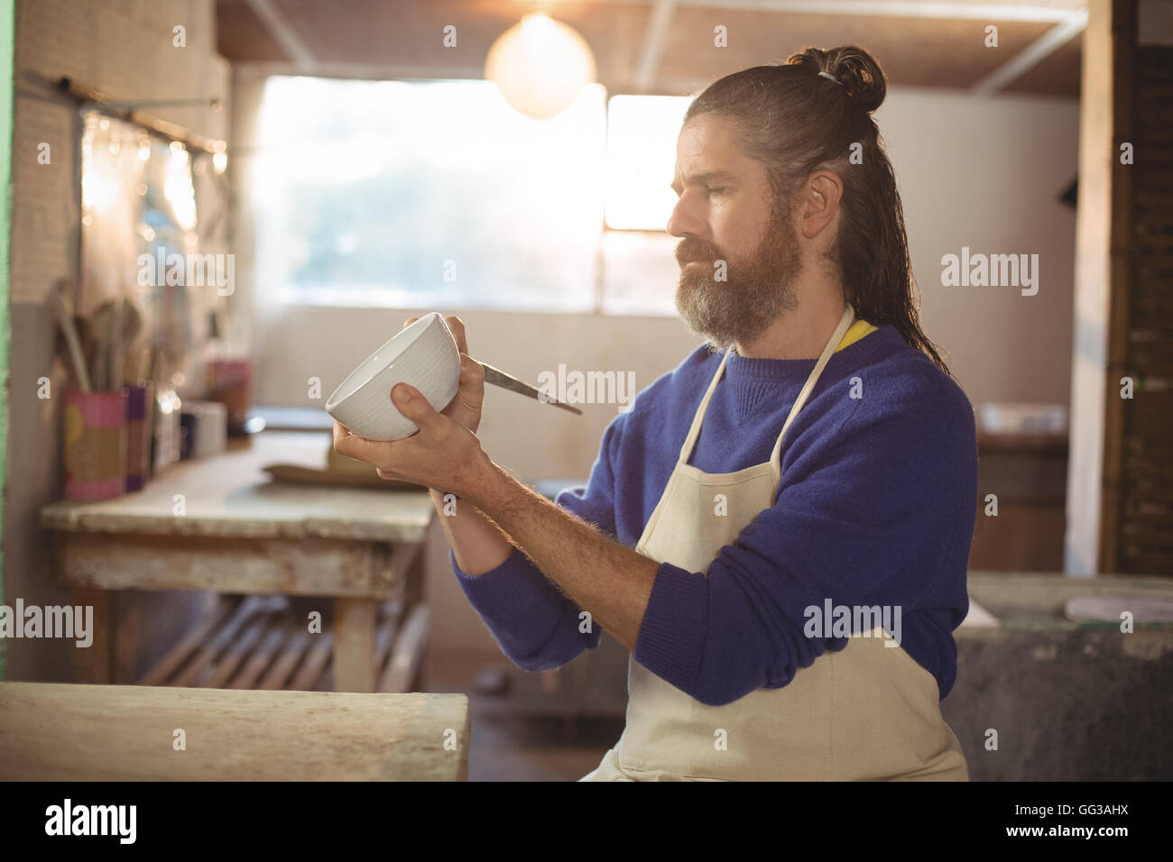 Attentive male potter painting on bowl Stock Photo - Alamy
