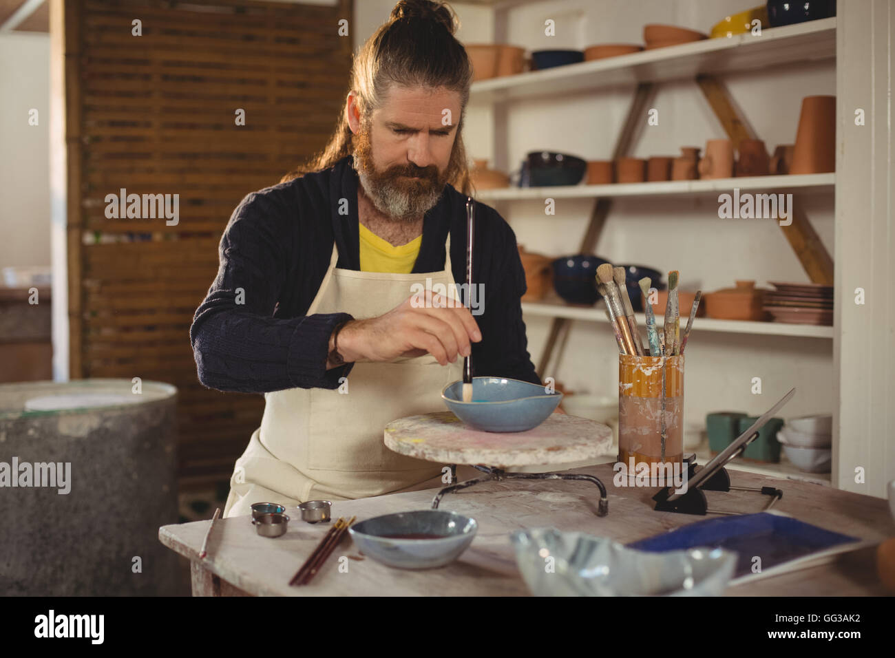 Attentive male potter painting on bowl Stock Photo - Alamy