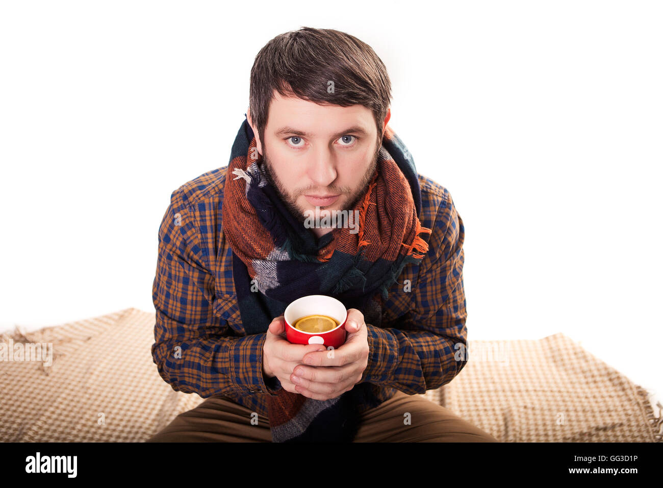 Handsome young man in winter clothes holding a cup of hot tea. Stock Photo