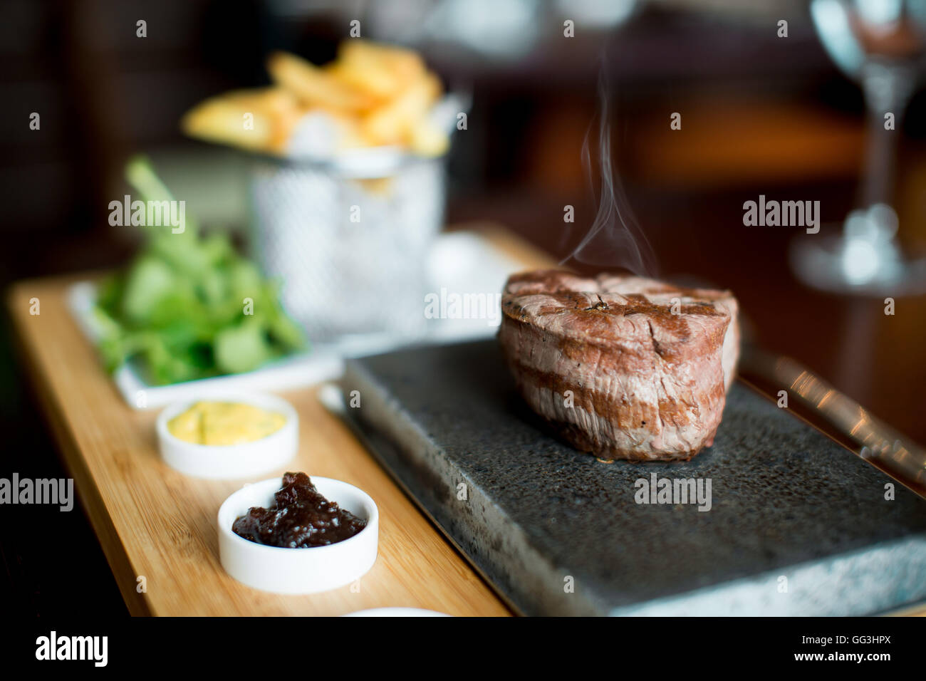 Fillet steak being cooked and cut on a hot stone in a restaurant Stock
