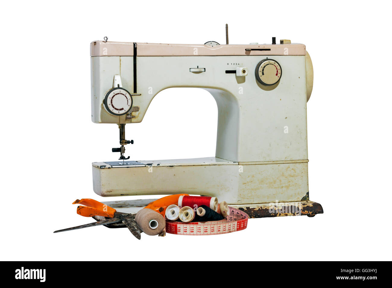 Old rusty vintage sewing machine with cotton reels, grungy scissors and