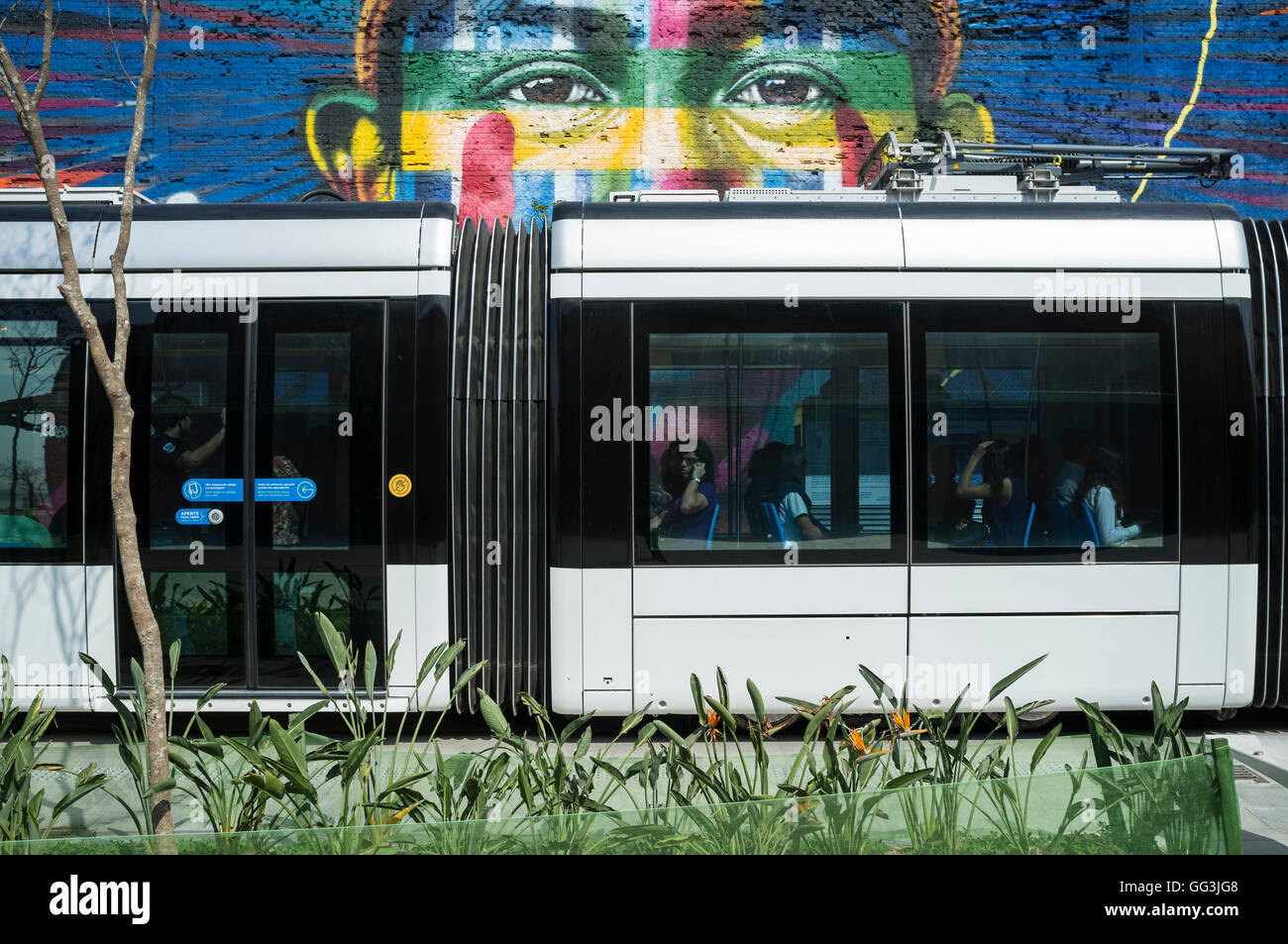 Rio de Janeiro Light Rail ( Portuguese - VLT do Rio de Janeiro or VLT Carioca ), a light rail system opened in June 2016 ahead of the 2016 Olympic Games passes in front of Eduardo Kobra s Mural named Native people from the 5 continents ( Povos nativos dos 5 continentes ) at Boulevard do Porto in Rio de Janeiro port surrounding area, Brazil, part of the Porto Maravilha Project ( Marvelous Port Program ), a revitalization project of the city Port Zone. Kobra is a Brazilian street artist notable for painting large murals, usually depicting portraits with a technique of repeating squares and trian Stock Photo
