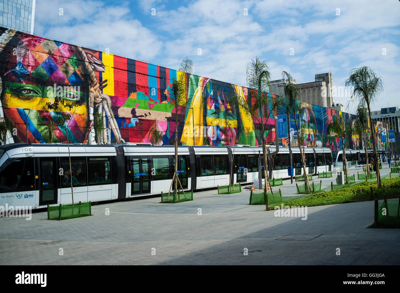 Rio de Janeiro Light Rail ( Portuguese - VLT do Rio de Janeiro or VLT Carioca ), a light rail system opened in June 2016 ahead of the 2016 Olympic Games passes in front of Eduardo Kobra s Mural named Native people from the 5 continents ( Povos nativos dos 5 continentes ) at Boulevard do Porto in Rio de Janeiro port surrounding area, Brazil, part of the Porto Maravilha Project ( Marvelous Port Program ), a revitalization project of the city Port Zone. Kobra is a Brazilian street artist notable for painting large murals, usually depicting portraits with a technique of repeating squares and trian Stock Photo