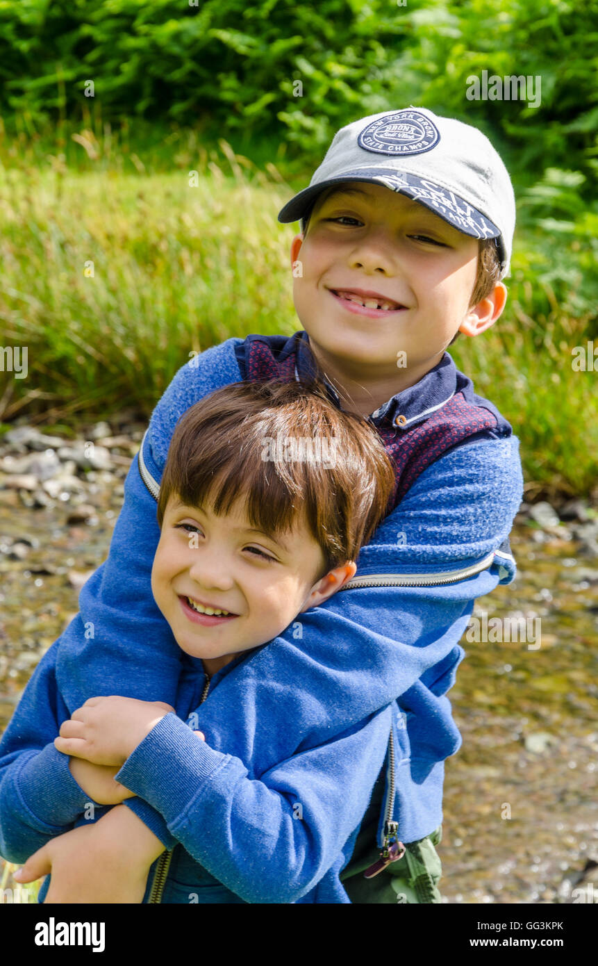 Young brothers hug outside on a day out in the countryside Stock Photo ...