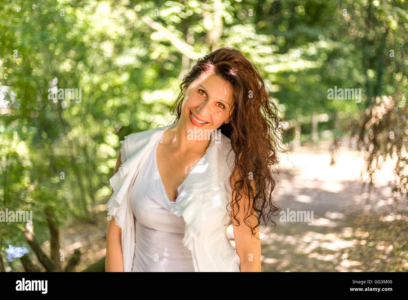 cute mature woman shakes her hair in a garden Stock Photo - Alamy