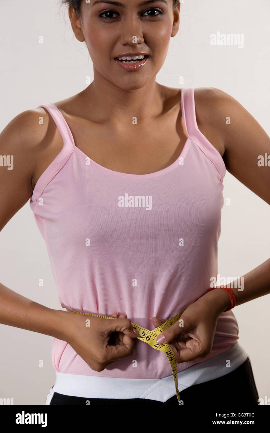 Woman measuring her waist Stock Photo - Alamy