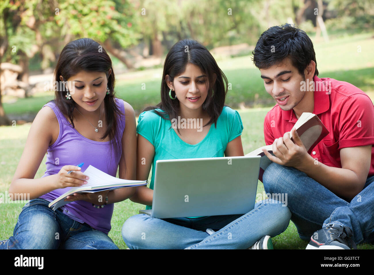 Students studying while sitting in lawn Stock Photo - Alamy