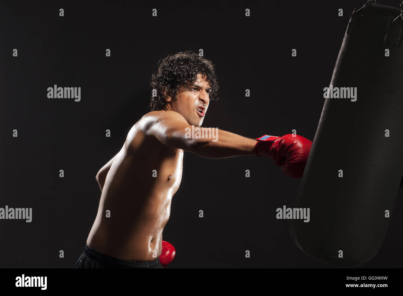 Young man hitting punching bag Stock Photo Alamy