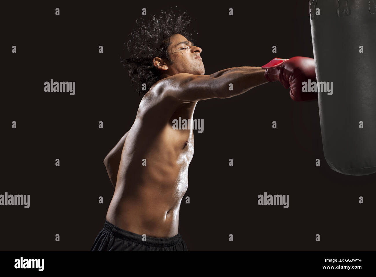 Boxer hitting punching bag aggressively Stock Photo Alamy