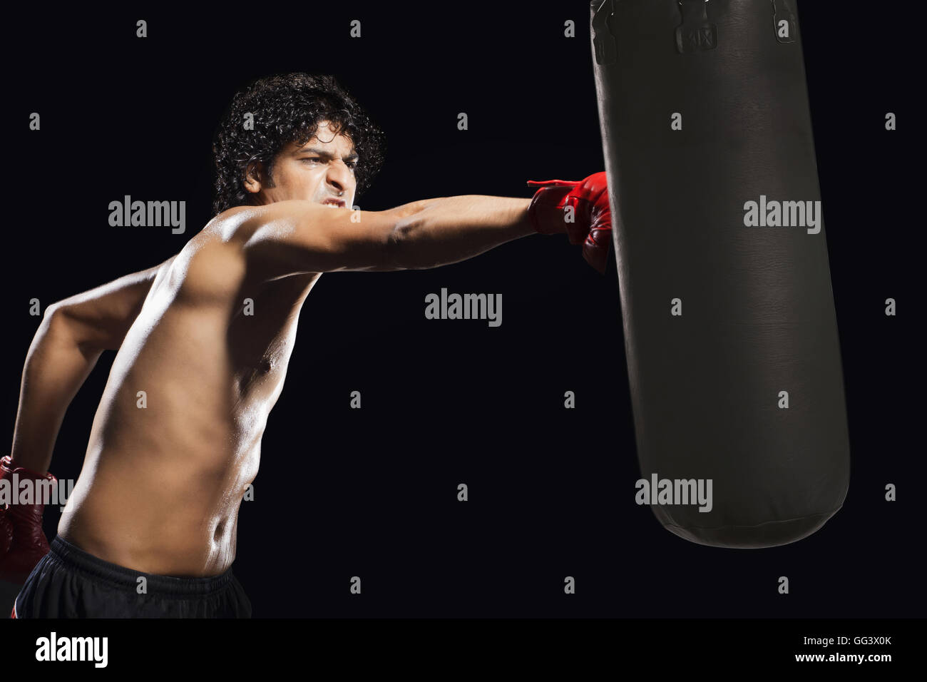 Man hitting heavy bag aggressively Stock Photo Alamy
