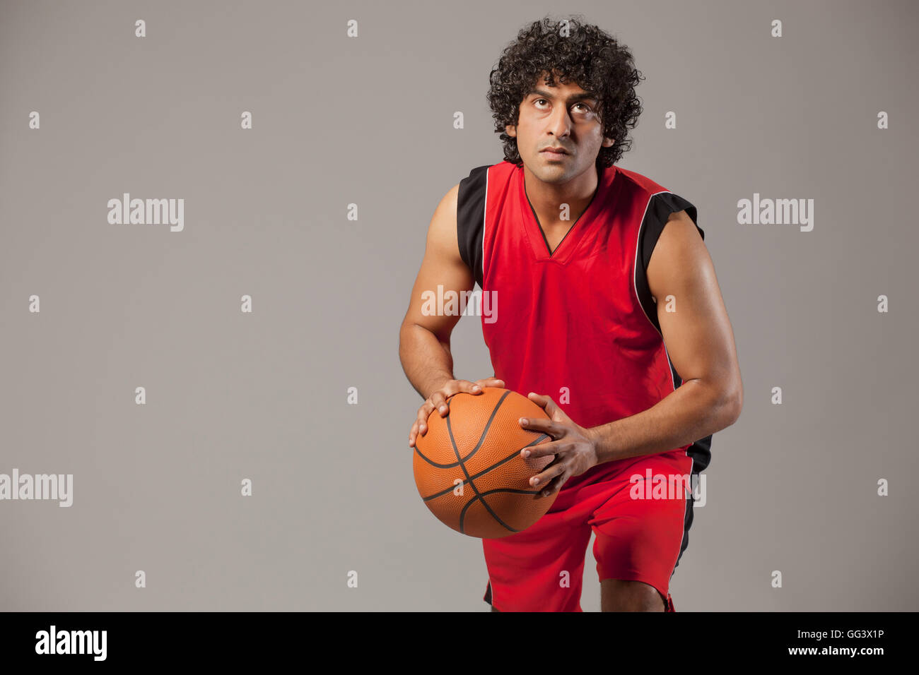 Basketball player lining up shot over grey background Stock Photo