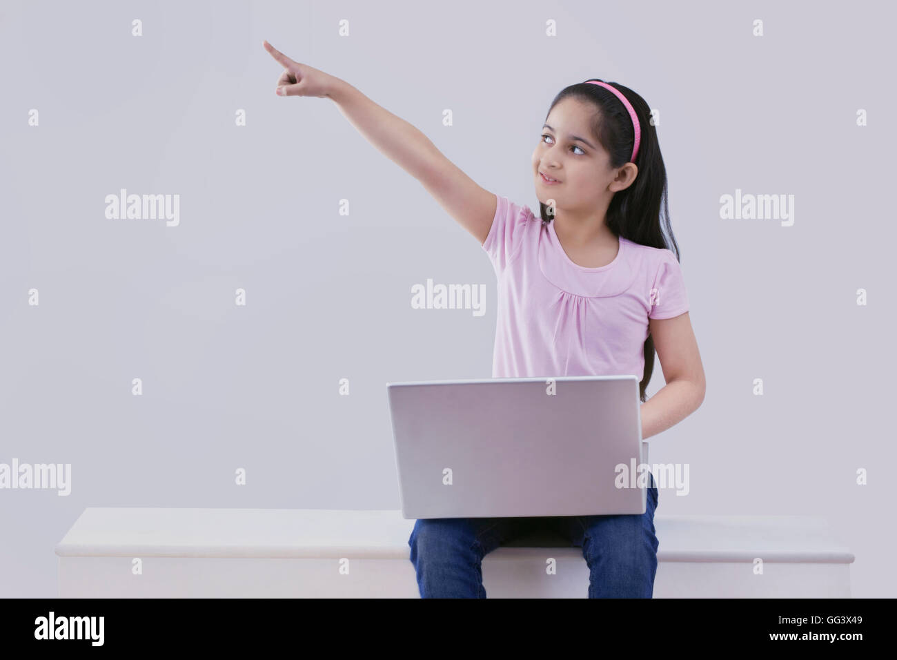 Little girl with a laptop pointing Stock Photo - Alamy