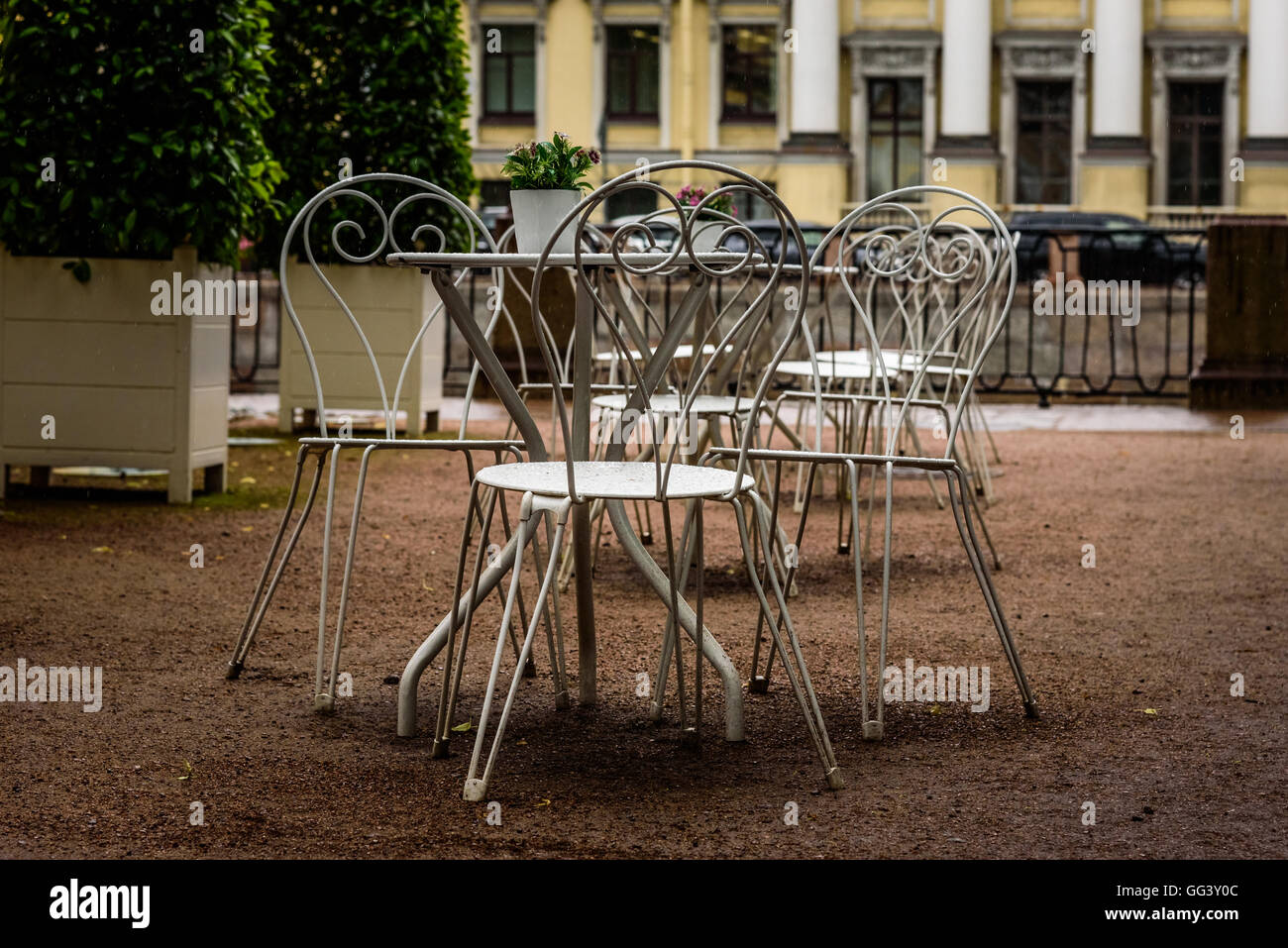 Modern set of white tables in the Park cafe in the rain Stock Photo
