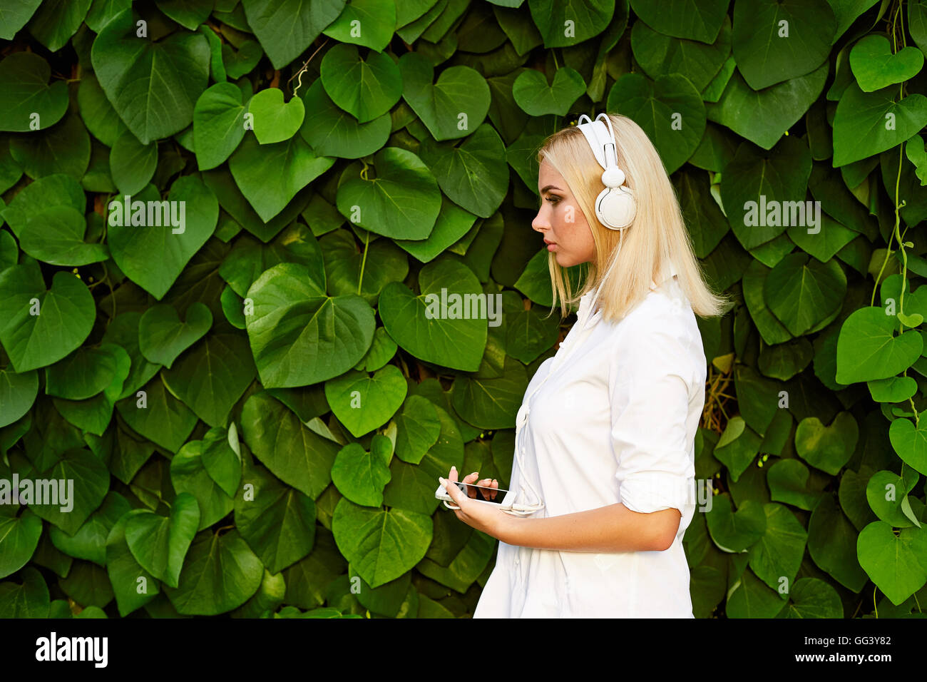 Blonde hair caucasian girl listening music with headphones Stock Photo ...