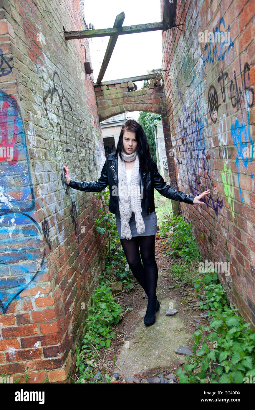 Model posing outside in alley way in black leather jacket Stock Photo