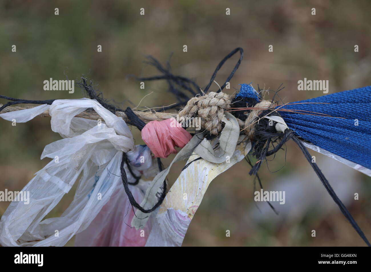Tied Up Ropes, Tightrope. Tightrope, brown rope, black rope and colored plastic bags tied up with blue shade netting. Stock Photo