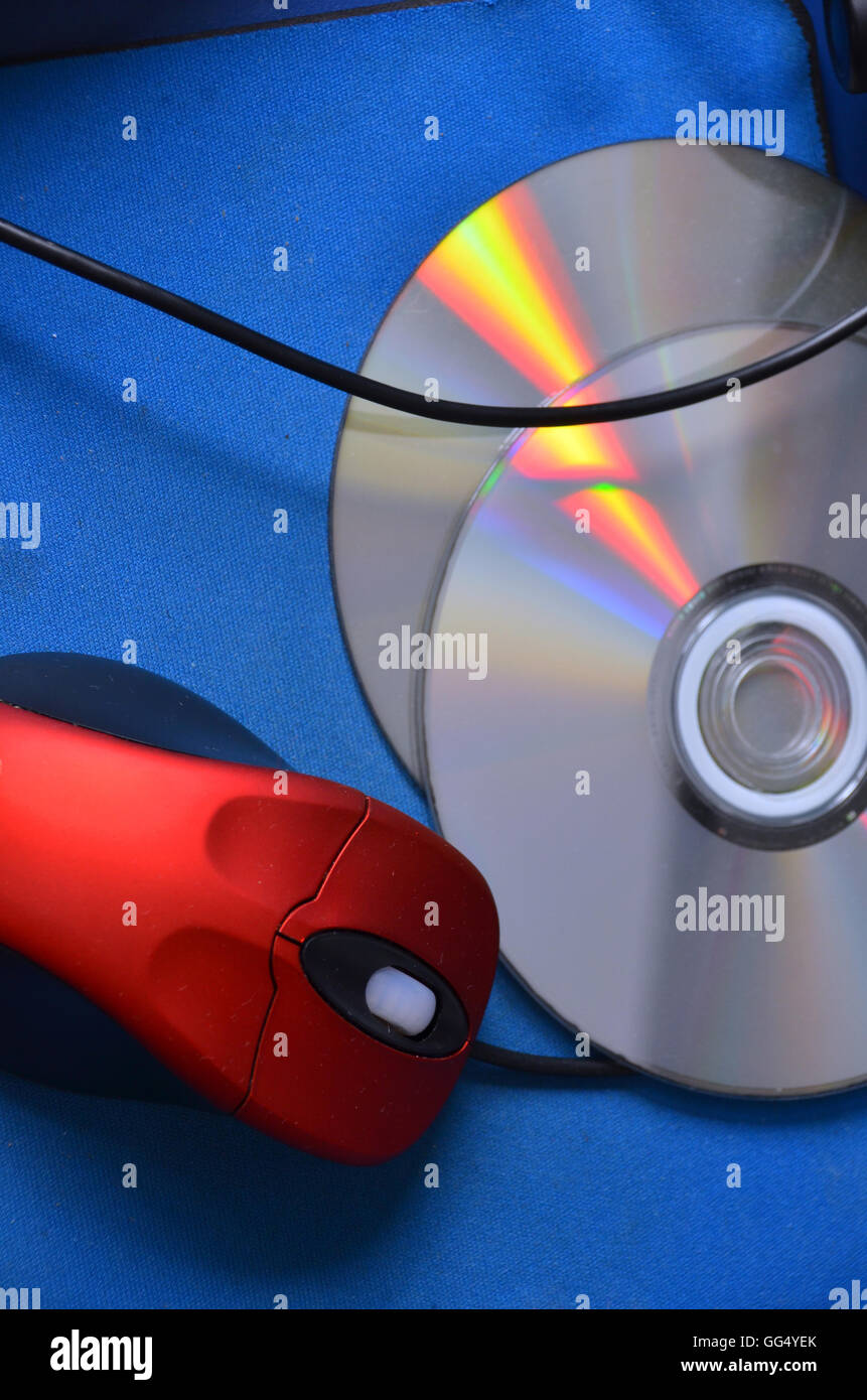 A red scrolling PC mouse, 2 gaming DVDs lie on a  mouse mat. Stock Photo