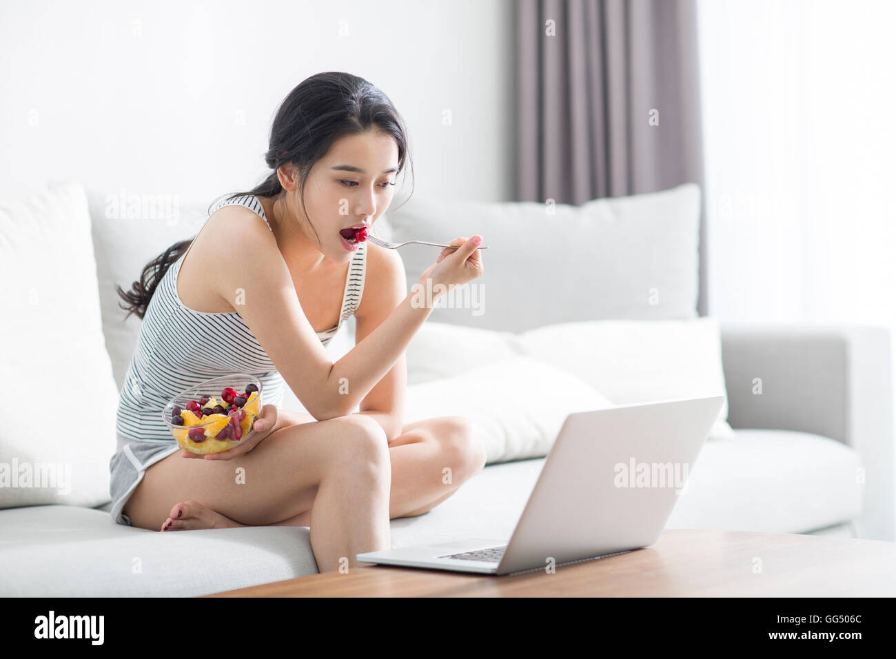 Young Chinese woman using laptop at home Stock Photo - Alamy