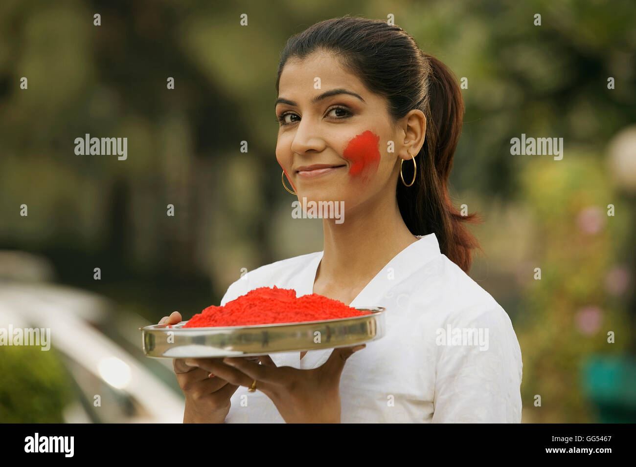 Woman holding a tray of gulal Stock Photo
