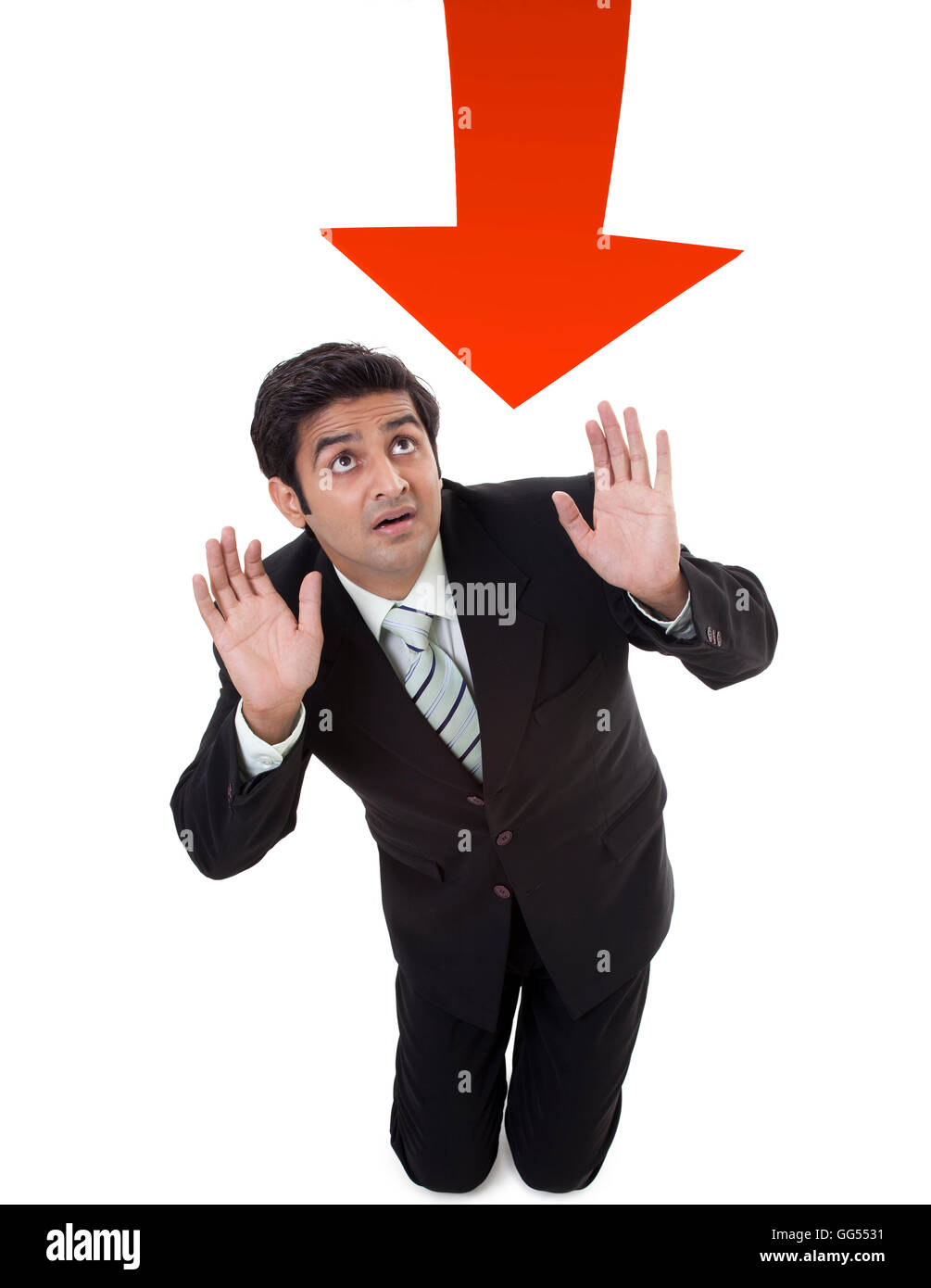 Young businessman protecting himself from arrow sign Stock Photo