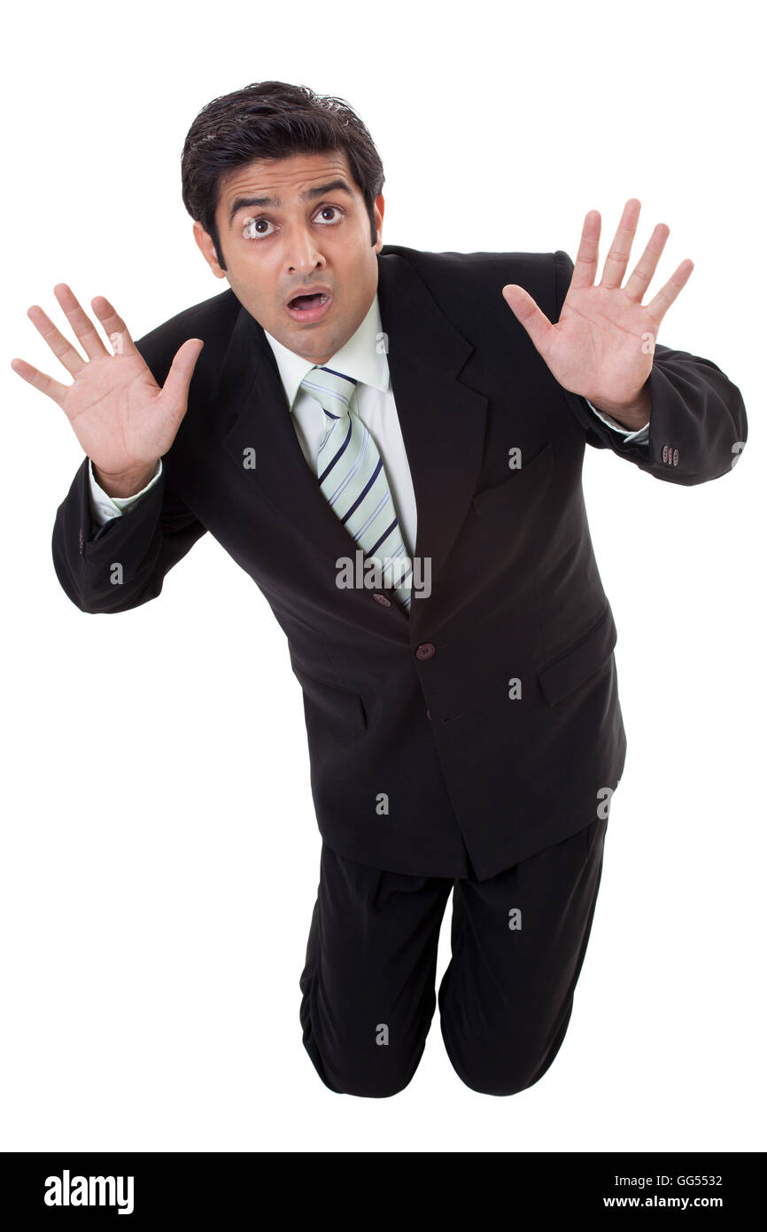 Scared young businessman protecting himself from something Stock Photo