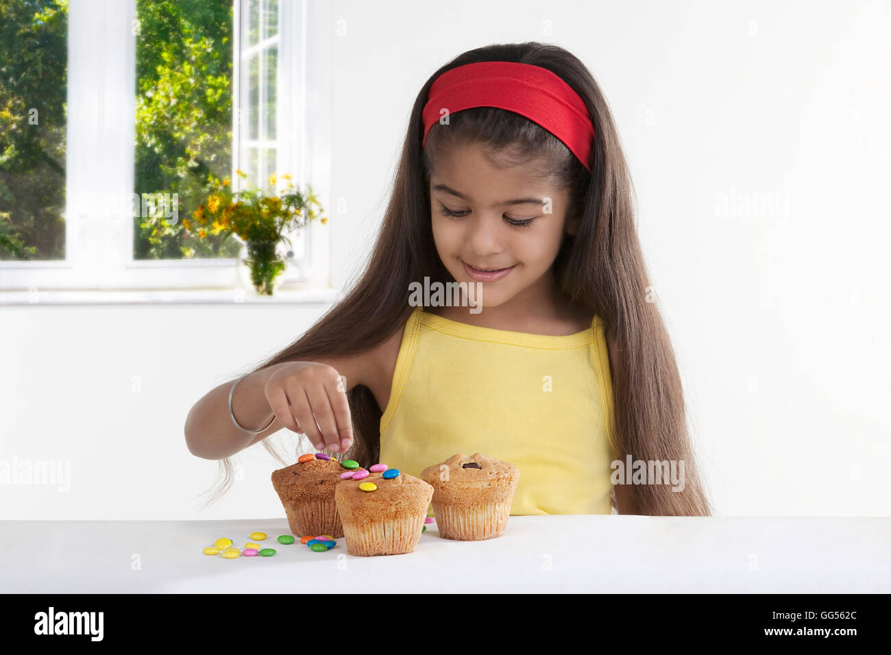 Girl decorating muffins Stock Photo