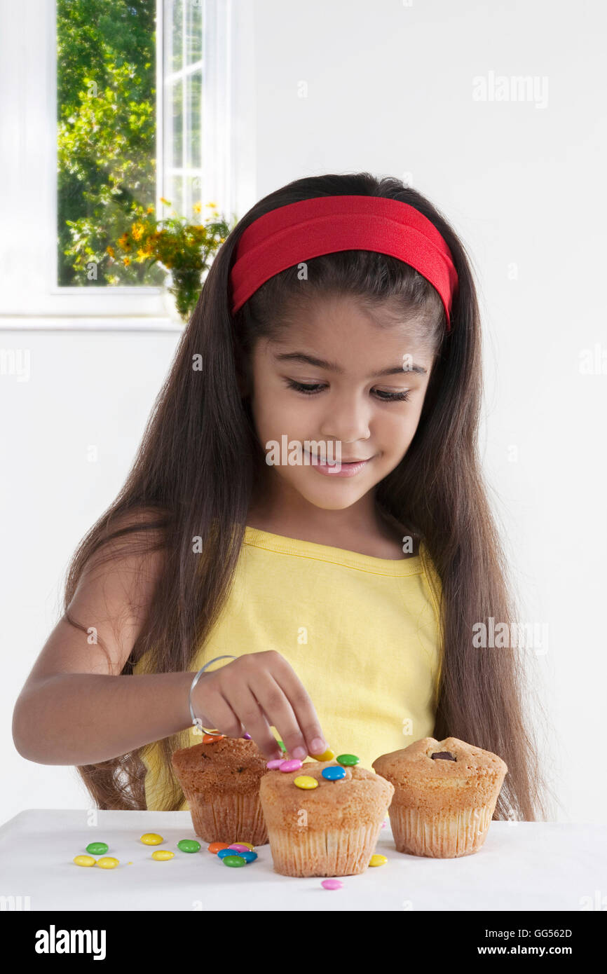 Girl decorating muffins Stock Photo