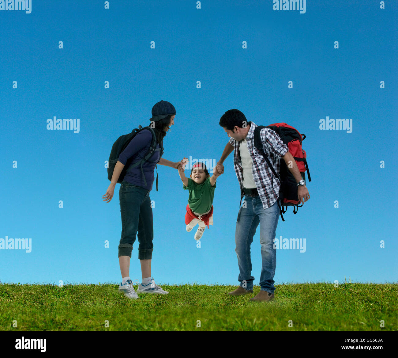 Parents swinging their son Stock Photo