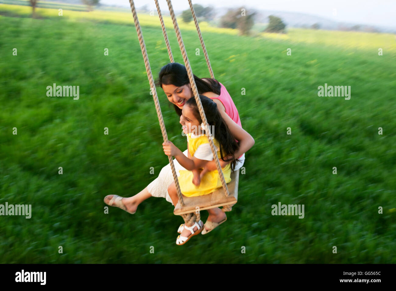 Mother and daughter having fun on a swing Stock Photo
