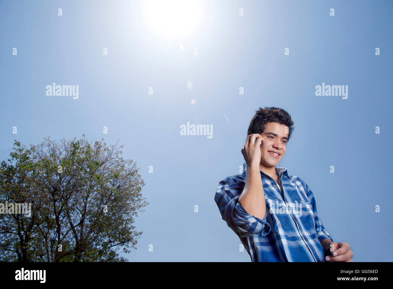 Low angle view of smiling young man with mobile phone Stock Photo