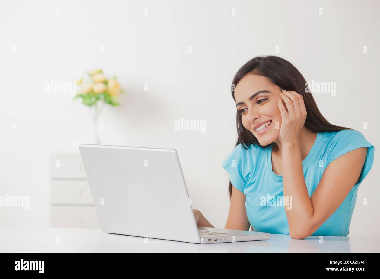 Happy young woman working on laptop at home Stock Photo - Alamy