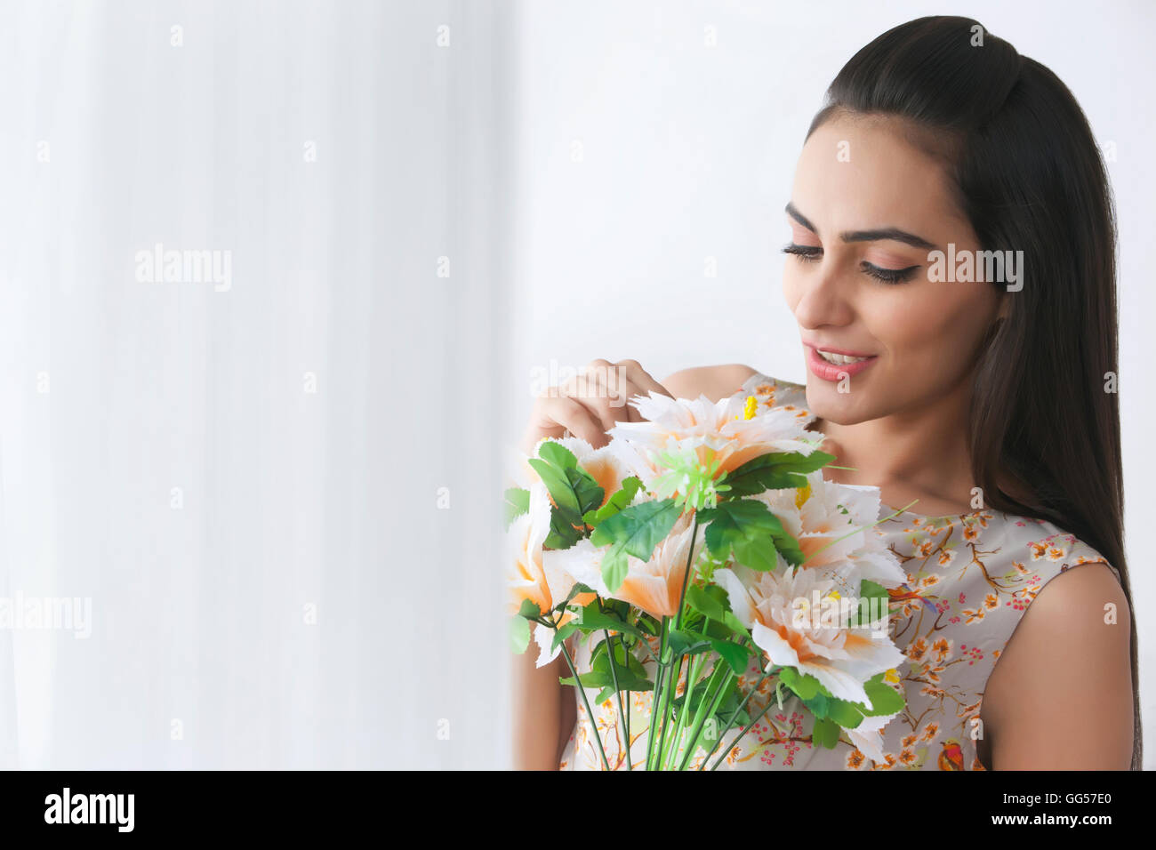 Beautiful young woman holding bunch of flowers Stock Photo - Alamy
