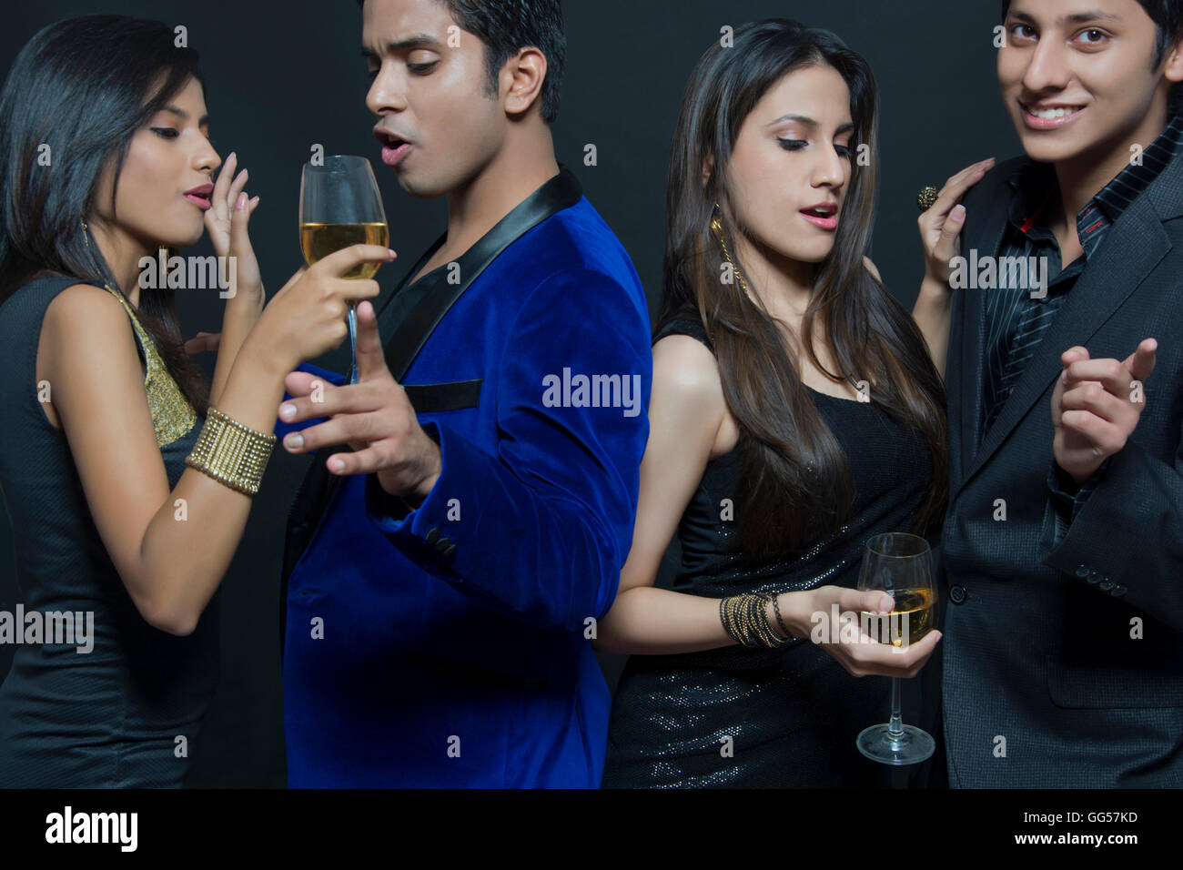 Young couples enjoying party over black background Stock Photo - Alamy