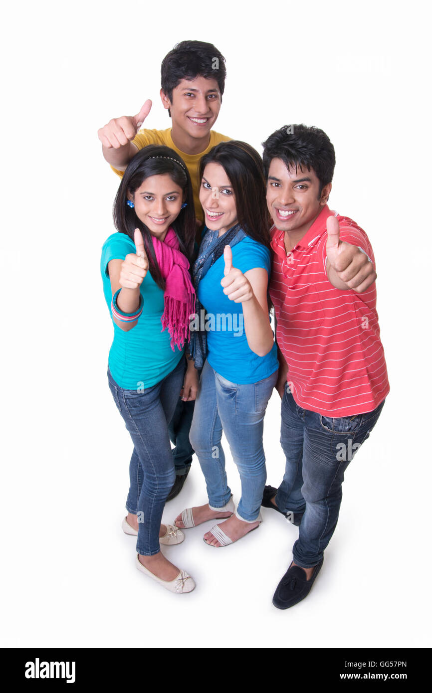 High angle portrait of college students gesturing thumbs up against white background Stock Photo