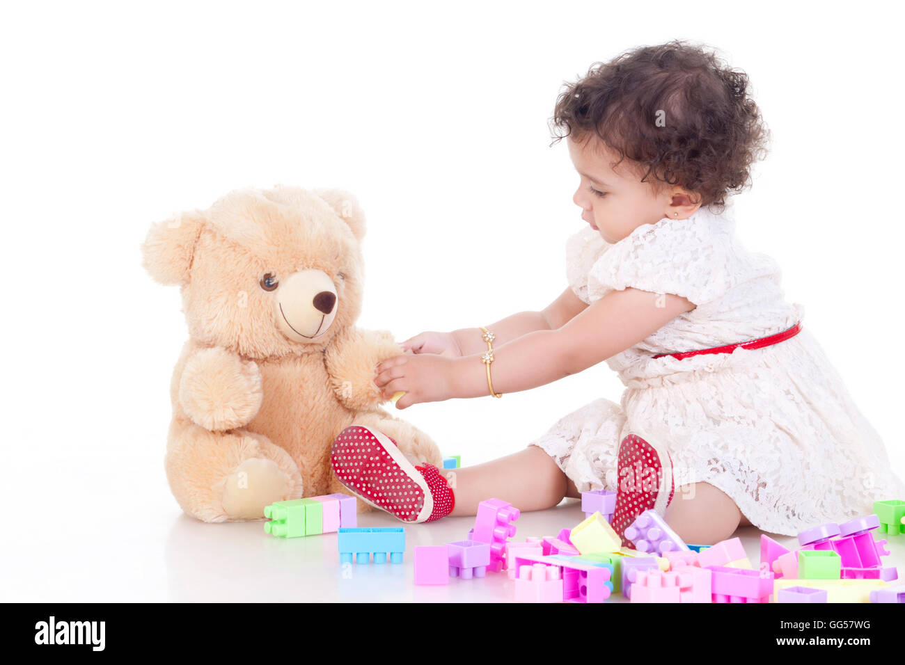 Full length of cute girl playing with stuffed toy over white background Stock Photo