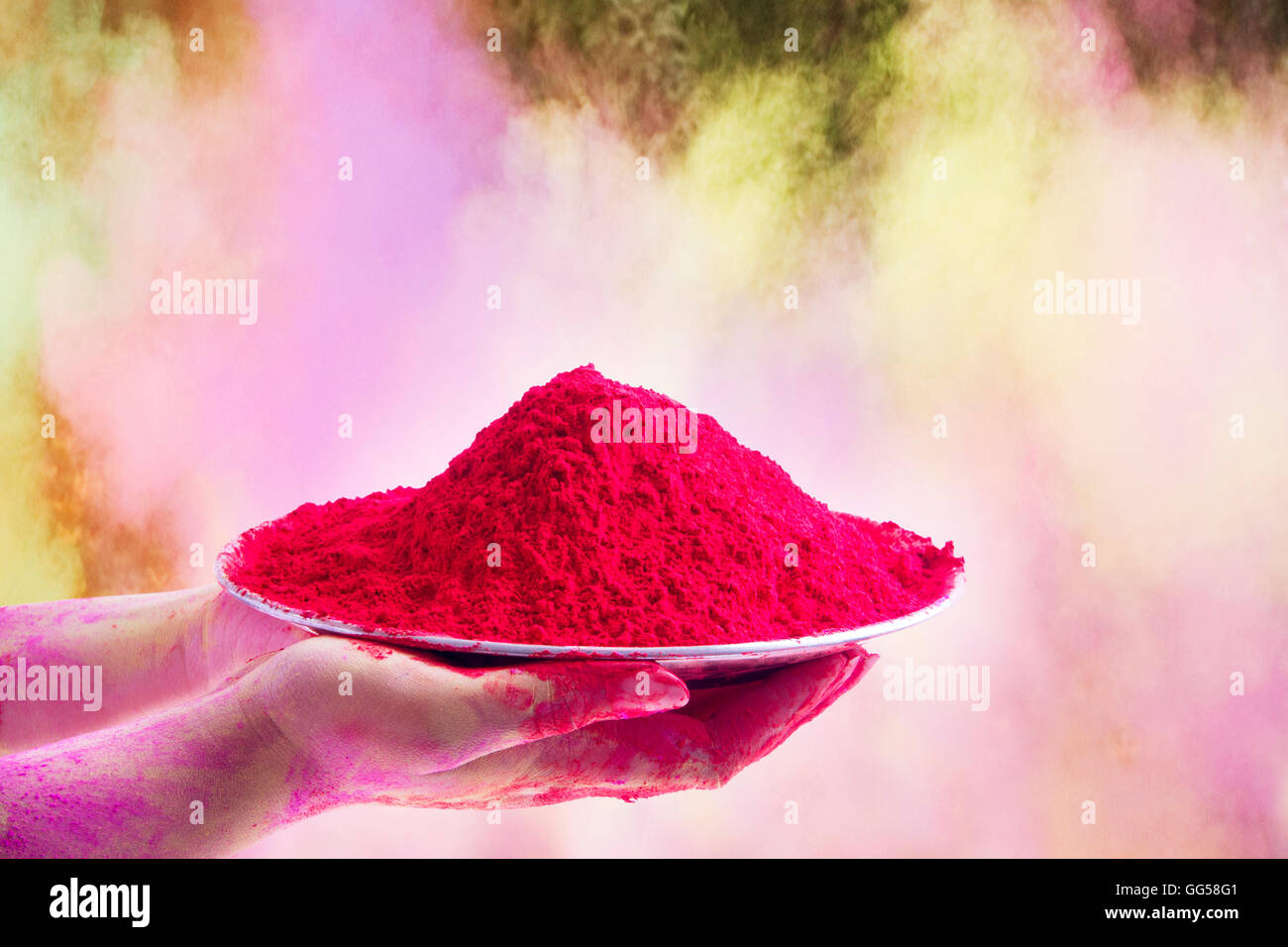 Close-up of hands holding plate with pink color gulal during Holi festival Stock Photo