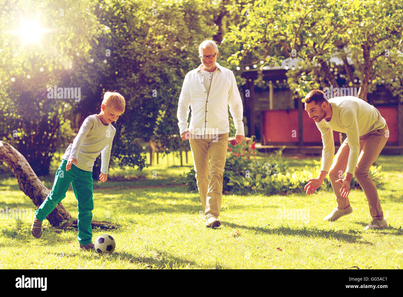 happy family playing football outdoors Stock Photo