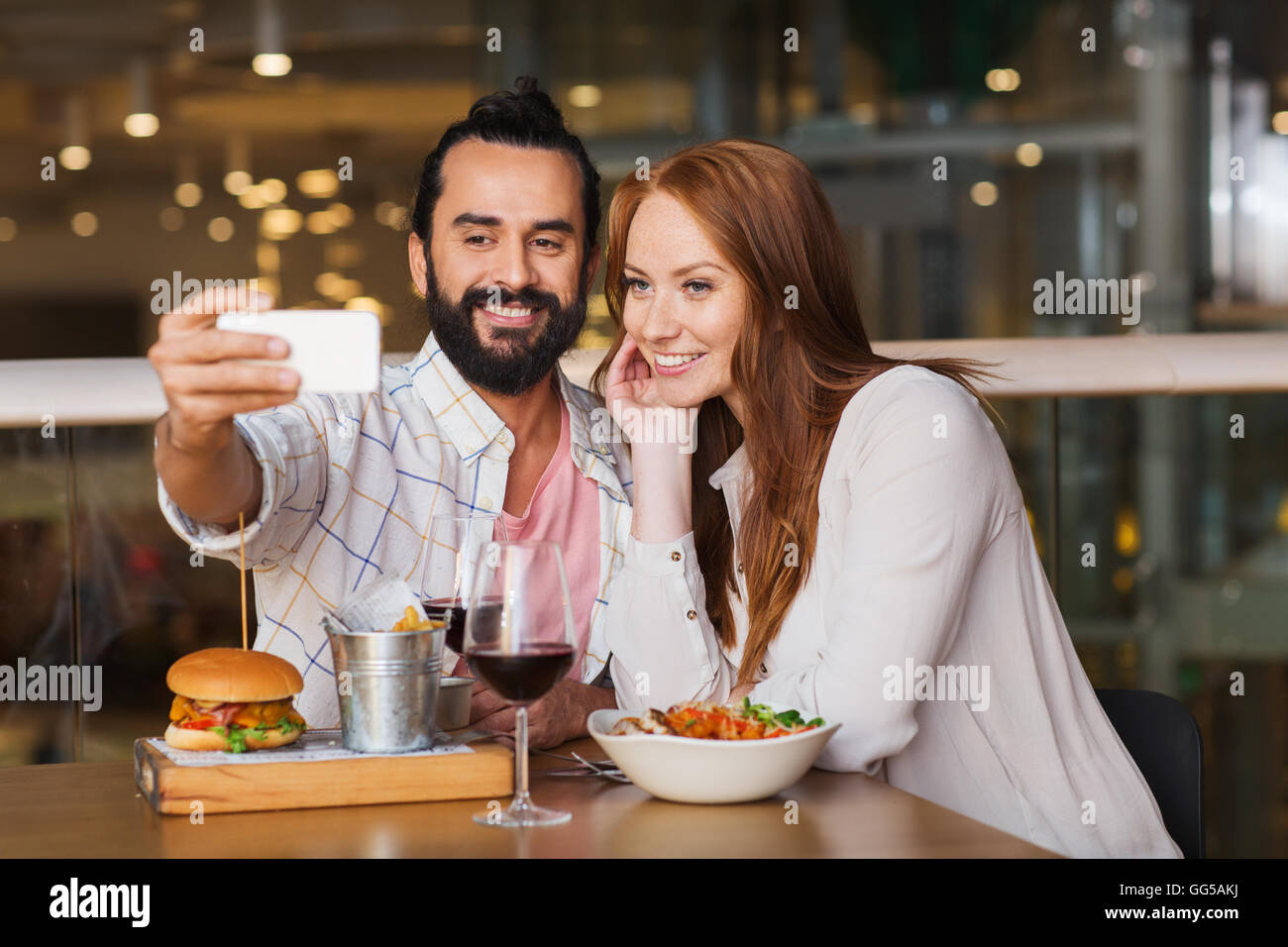 couple taking selfie by smartphone at restaurant Stock Photo