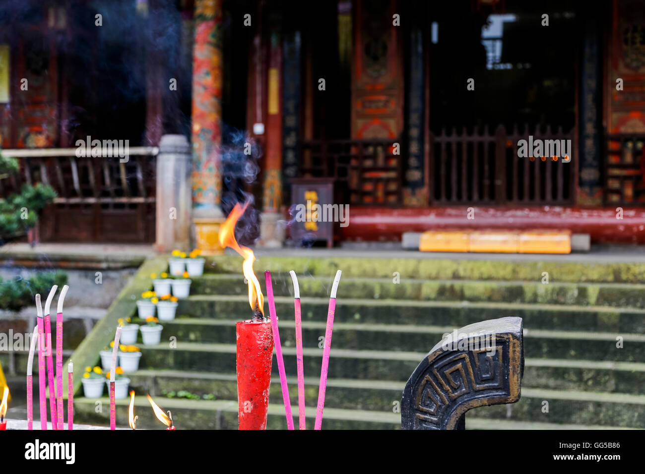 Candles and incense sticks burning in front of a Buddhist temple on Mt. Emei (Emeishan), Leshan, Sichuan, China Stock Photo