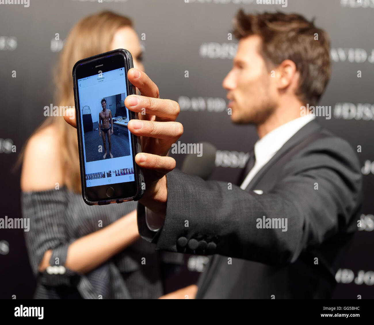 Sydney, Australia. 03rd Aug, 2016. David Jones Ambassador and X-Factor host Jason Dundas show a photo of his fit body to the camera during a media interview on the black carpet prior to his appearance on the runway for the David Jones Spring/Summer 2016 Fashion Launch at Fox Studios © Hugh Peterswald/Pacific Press/Alamy Live News Stock Photo